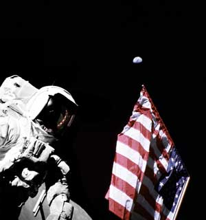 Фото NASA AS17-134-20384. Астронавт Харрисон Шмитт, флаг и Земля.